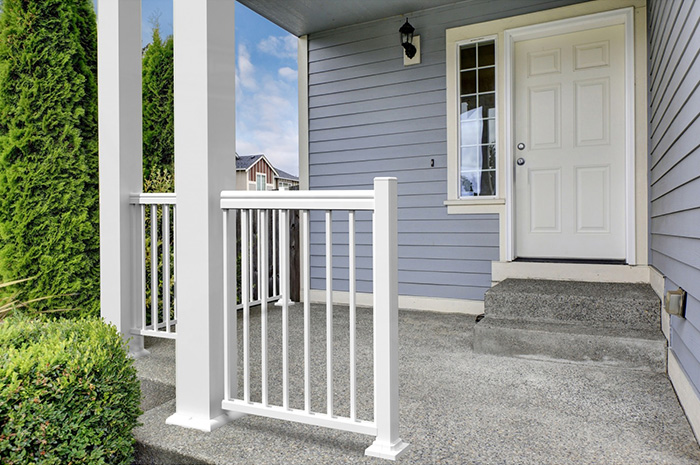 Front porch with a white railing and two square white columns